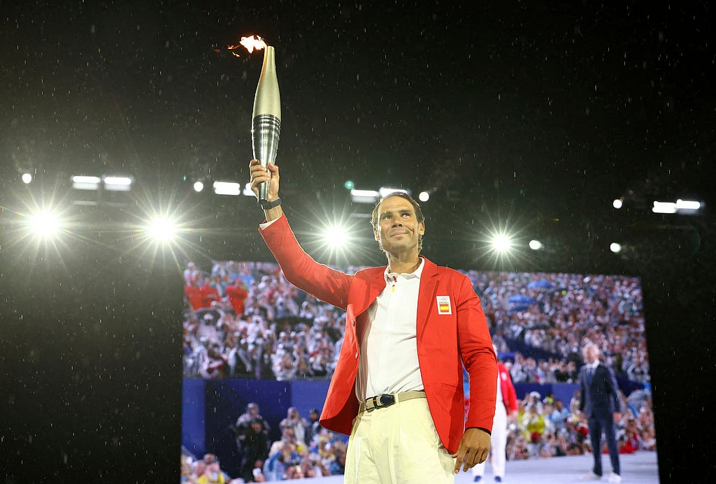 Rafael Nadal, of Spain, carries the Olympic torch during the opening ceremony of the 2024 Summer Olympics, Friday, July 26, 2024 in Paris, France