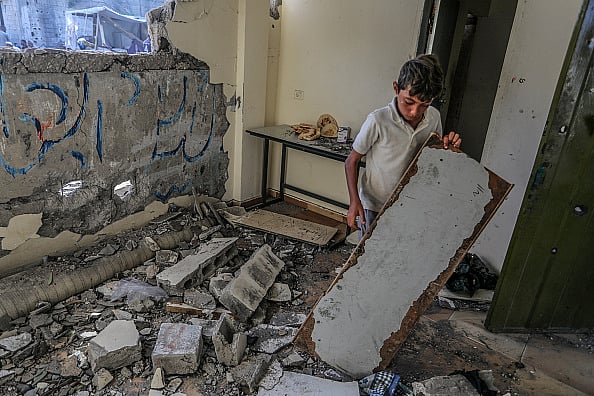Palestinians investigate the heavily damaged Al-Awda school building following the Israeli attack in Abasan district of Khan Yunis, Gaza on July 10, 2024.  - Getty Images