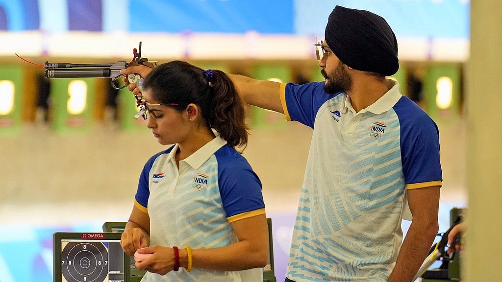 AP/Manish Swarup : India's Manu Bhaker, left, and teammate Sarabjot Singh compete in the 10m air pistol mixed team qualification round at the 2024 Summer Olympics, Monday, July 29, 2024, in Chateauroux, France. 