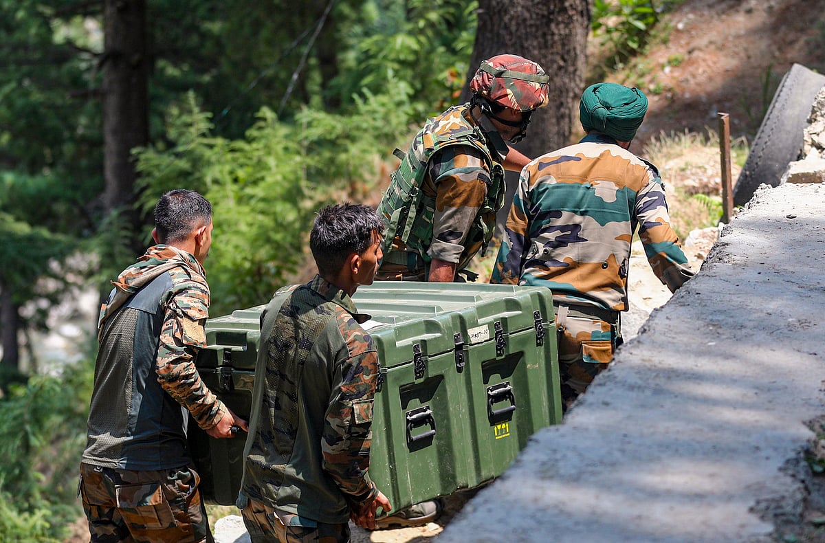 PTI : Army personnel carry weapons and equipment near the encounter site, in Desa village of Doda district