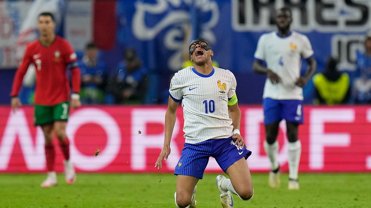 Kylian Mbappe of France, centre, falls after a collision with Portugals Joao Palhinha during a quarter-final match at the Euro 2024. AP Photo