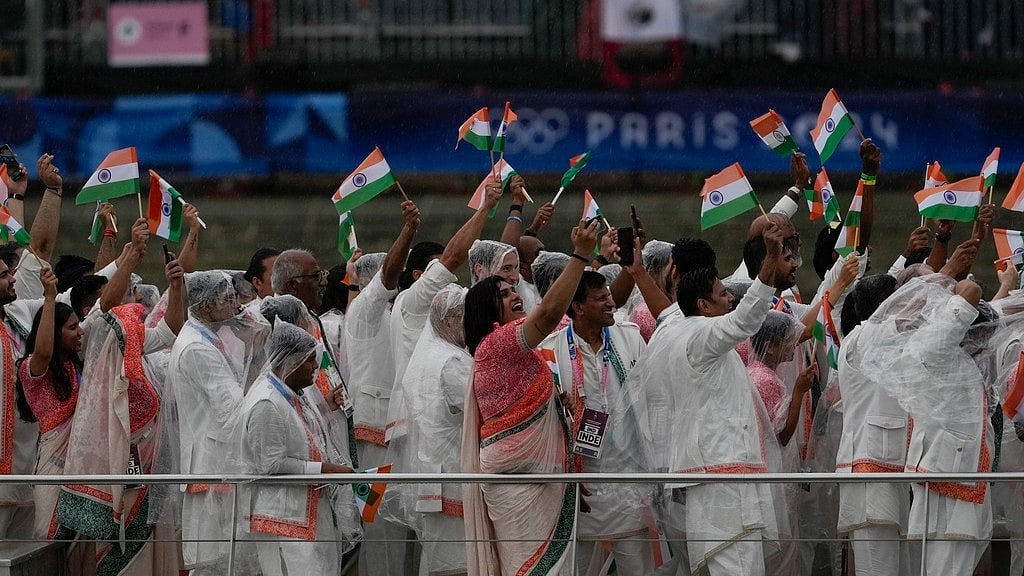 Members of Team India wave flags as they travel along the Seine River in Paris, France, during the opening ceremony of the 2024 Summer Olympics. - AP/Anjum Naveed
