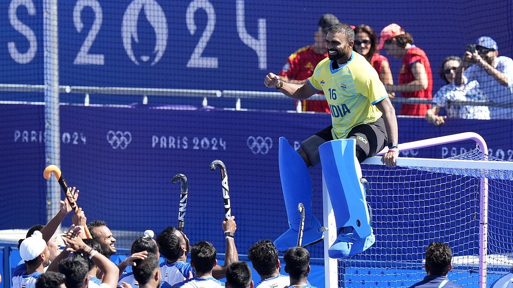 PR Sreejesh (in yellow jersey) sits on the goal cross-bars as India's players celebrate after winning the bronze medal match against Spain at the Paris Olympics. - AP