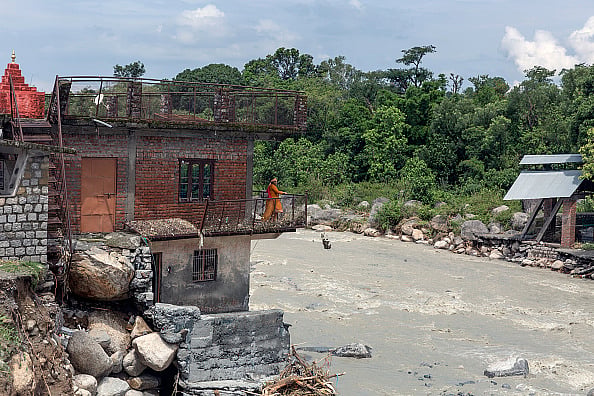  (Photo by Shailesh Bhatnagar  via Getty Images) : A woman clears the debris from her house which was damaged due to a flash flood after heavy rain 