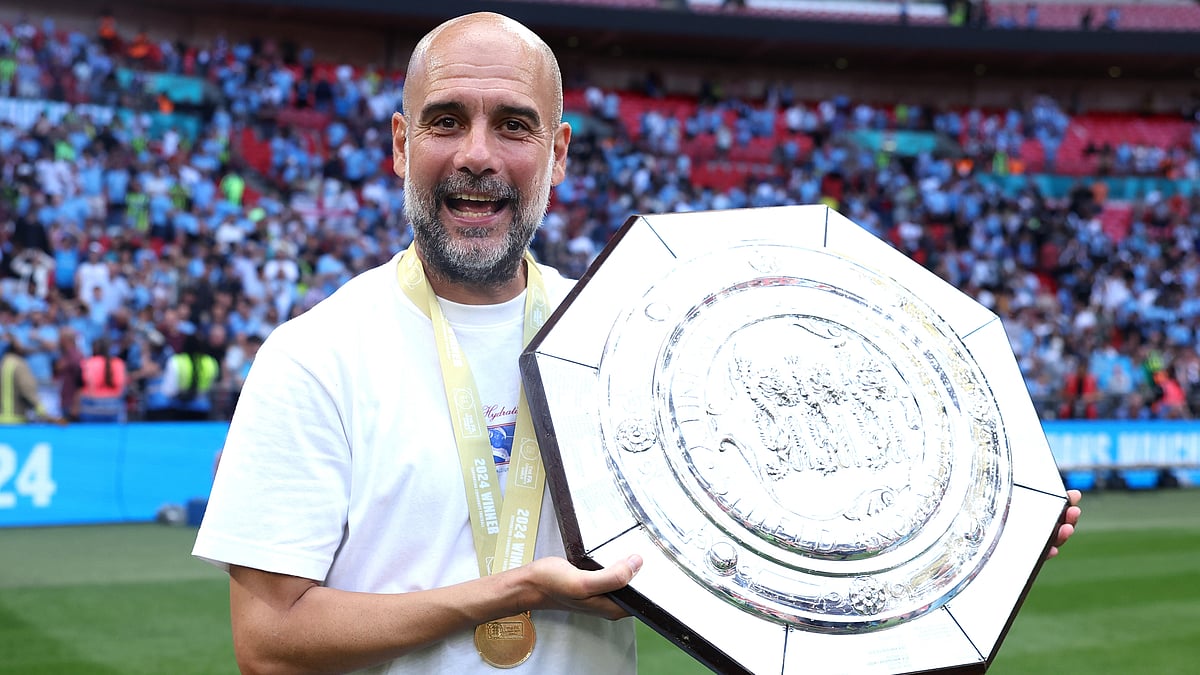 Pep Guardiola holds the Community Shield after Saturday's win.