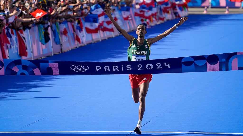 AP : Ethiopia's Tamirat Tola celebrates after crossing the finish line to win the gold medal at the end of the men's marathon competition at the 2024 Summer Olympics.