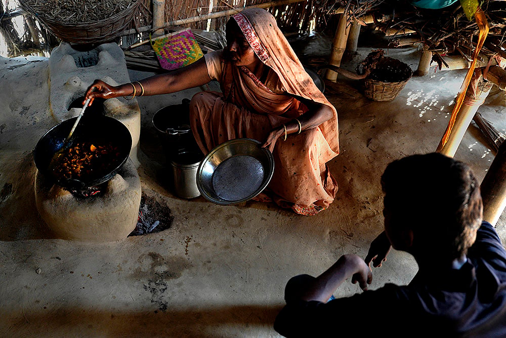 Deepak’s mother cooking food at their mud house