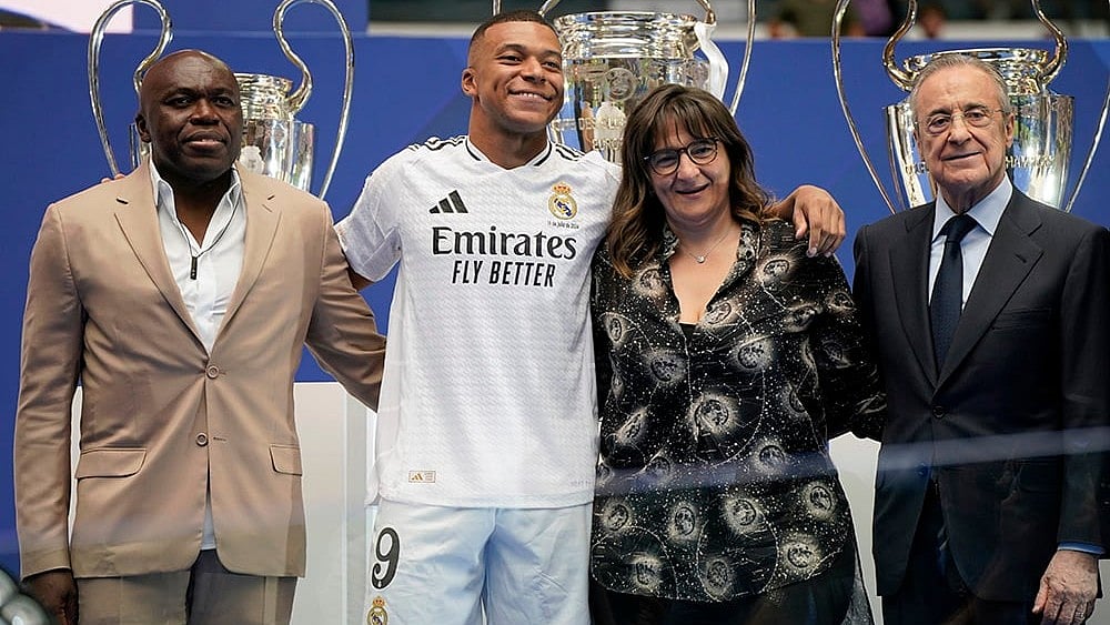 Kylian Mbappe poses with his parents and Florentino Perez - | Photo: AP/Andrea Comas