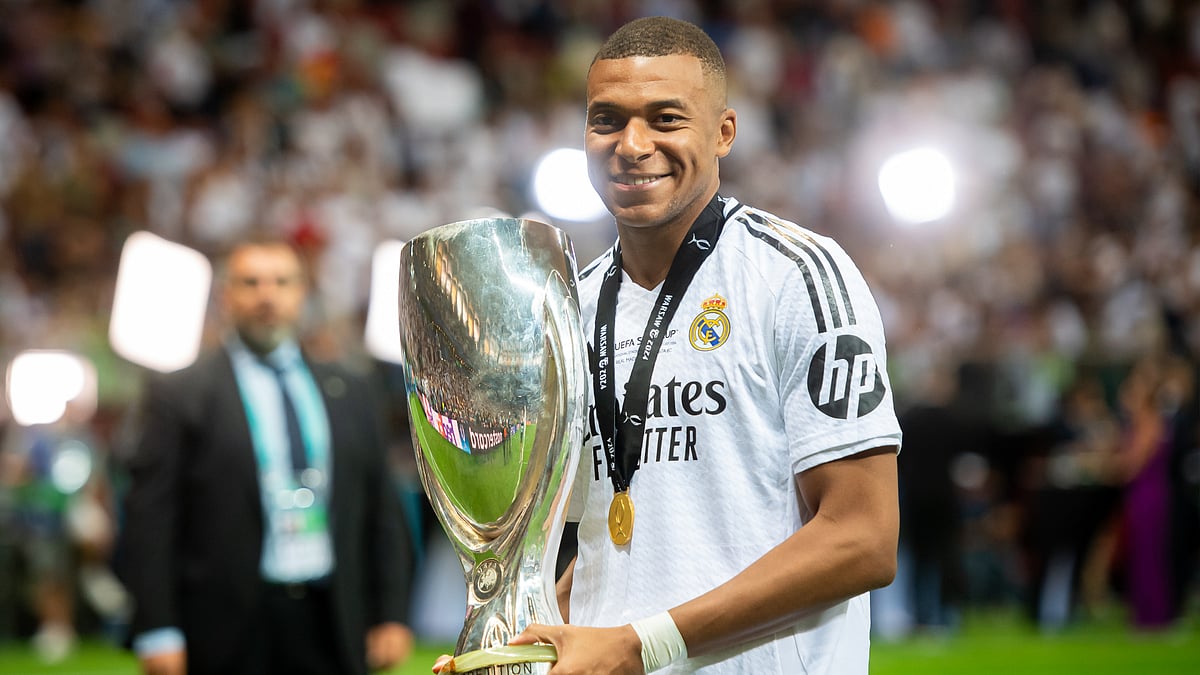 Kylian Mbappe poses with the UEFA Super Cup trophy.