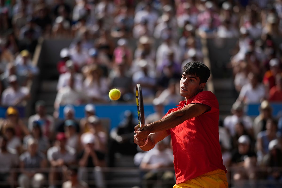 (AP Photo/Louise Delmotte) : Spain's Carlos Alcaraz Spain's Carlos Alcaraz backhands to Serbia's Novak Djokovic during the men's singles tennis final at the Roland Garros stadium during the 2024 Summer Olympics, Sunday, Aug. 4, 2024, in Paris, France. 