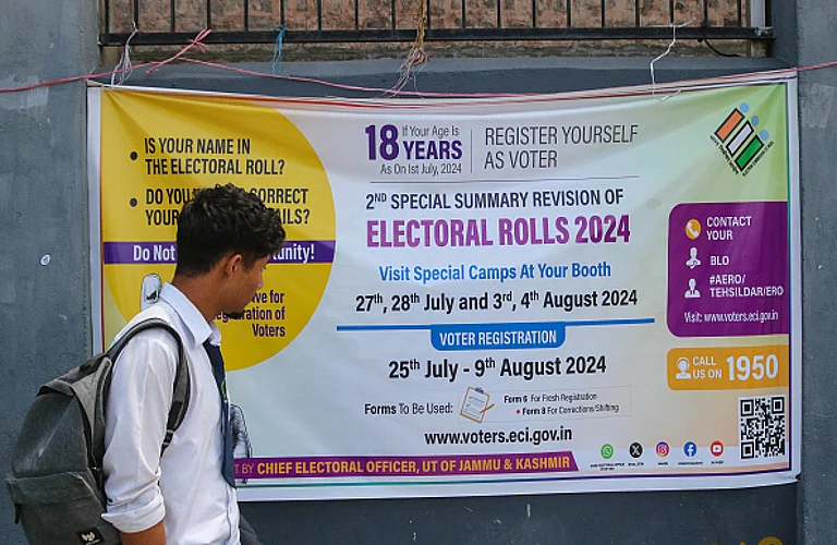 A student is looking at the Election banner as he is walking along a road in Srinagar, Jammu and Kashmir, on August 07, 2024. - (Photo by Firdous Nazir/NurPhoto via Getty Images)