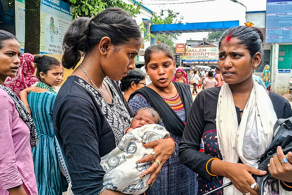 Woman with newborn child outside district hospital during Doctors strike at Siliguri, in Darjeeling