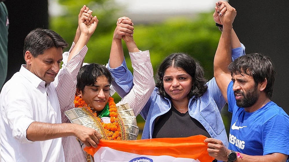 Wrestler Vinesh Phogat with Bajrang Punia and Sakshi Malik  - | Photo: PTI/Ravi Choudhary