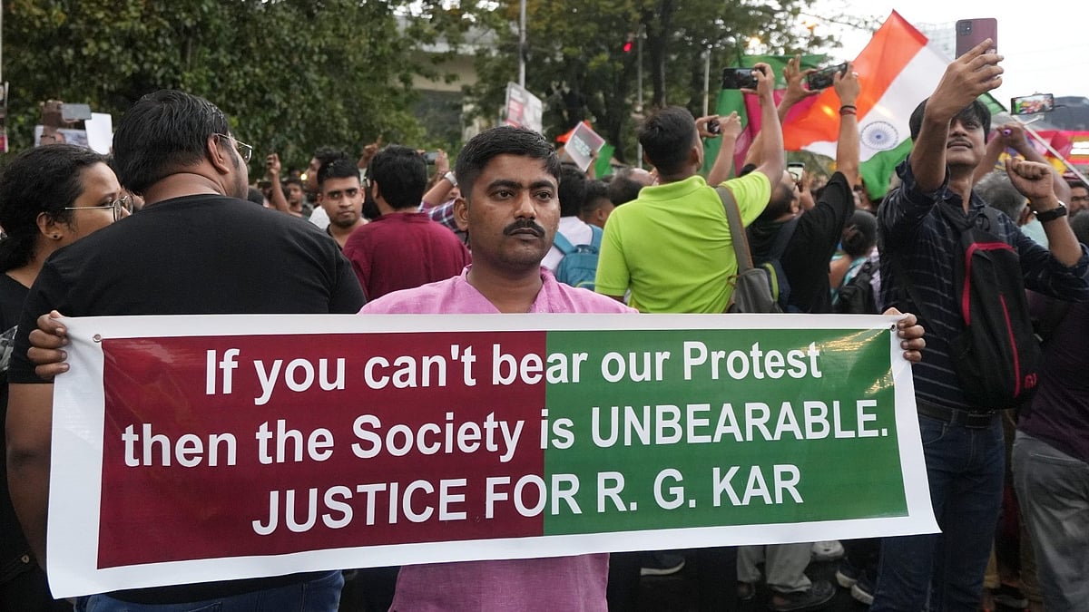 PTI : A protester holds a placard against the alleged rape and murder of a postgraduate trainee doctor, near Salt Lake stadium in Kolkata on Sunday (August 18, 2024). 