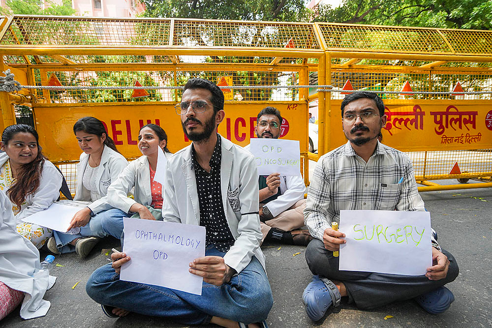 Doctors display placards offering OPD facility during a protest at Nirman Bhawan in New Delhi