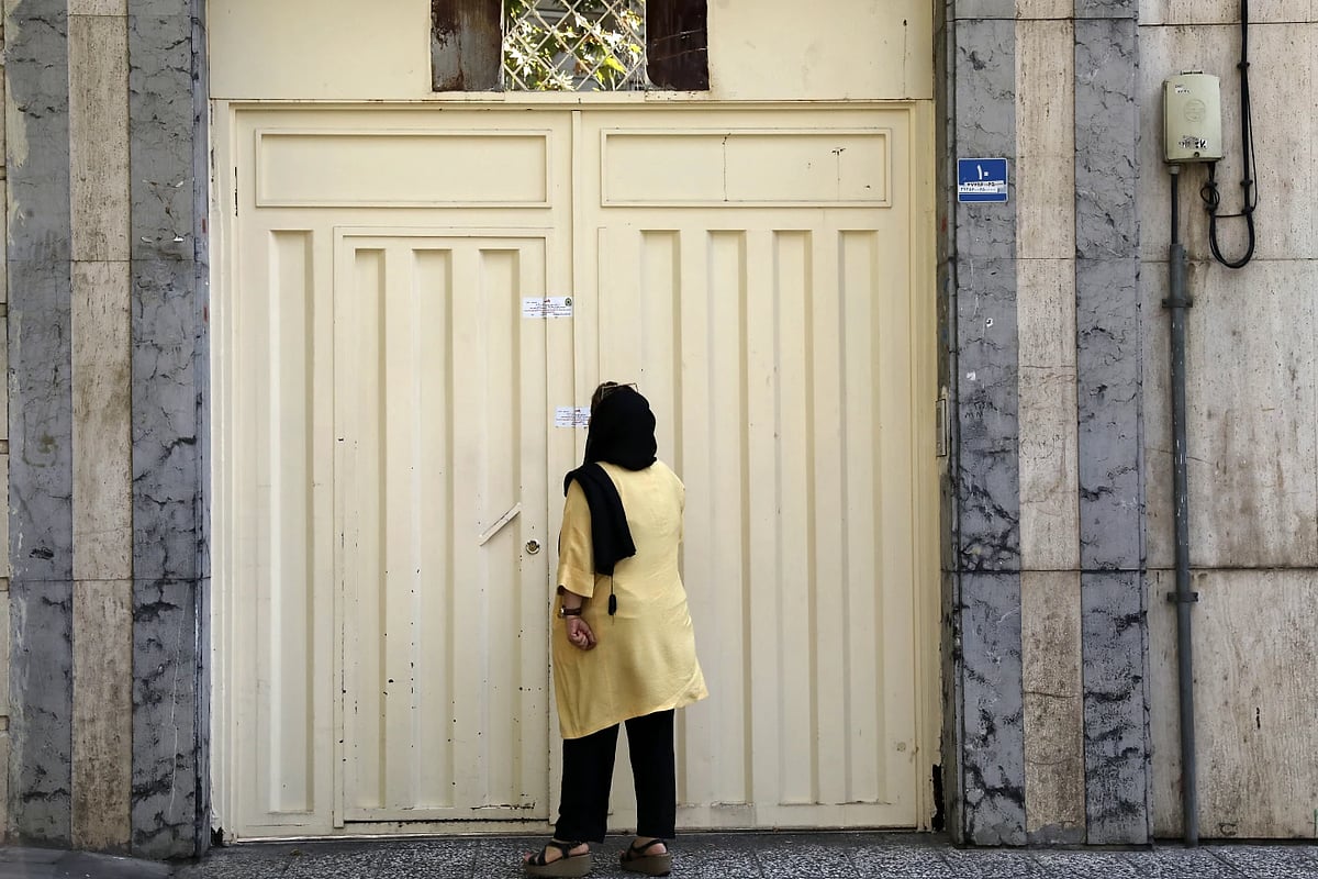 AP : A woman reads the closure notice on German teaching institute in Tehran |