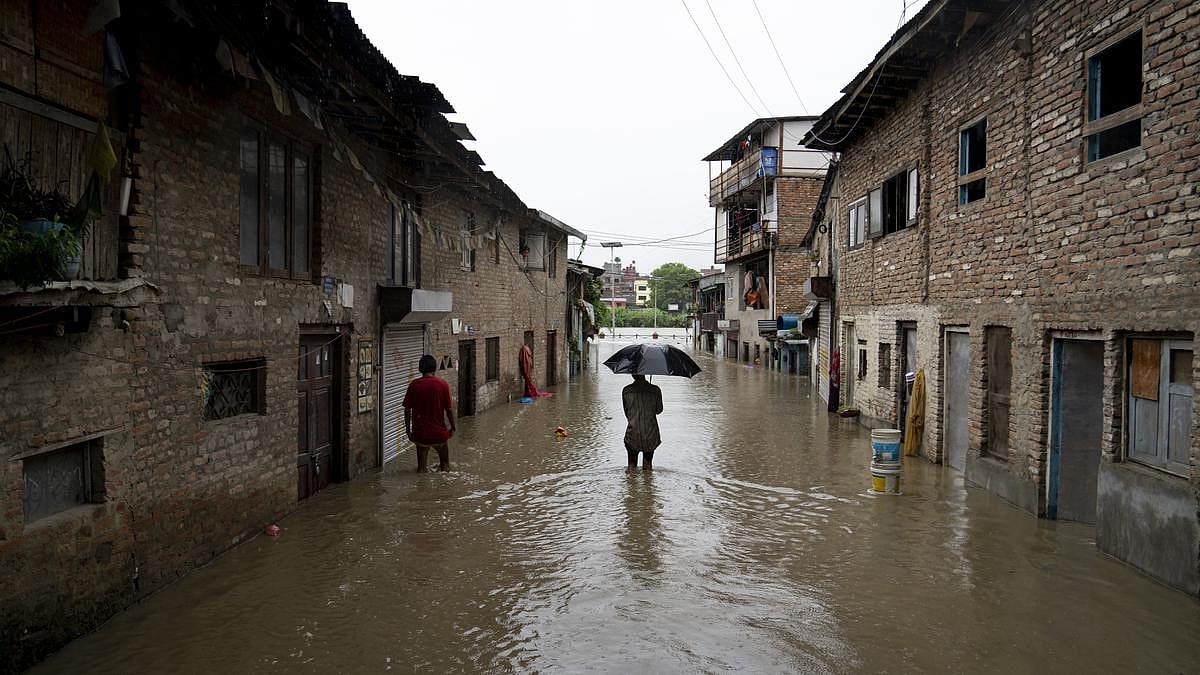 A man walking through a flooded lane near Bagmati River in Kathmandu - AP