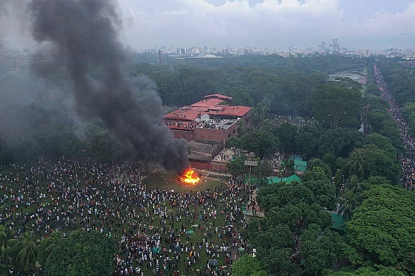 In this aerial view, fires burn outside the Prime Minister's House after Bangladesh Prime Minister Sheikh Hasina resigned and fled the country. - Drik