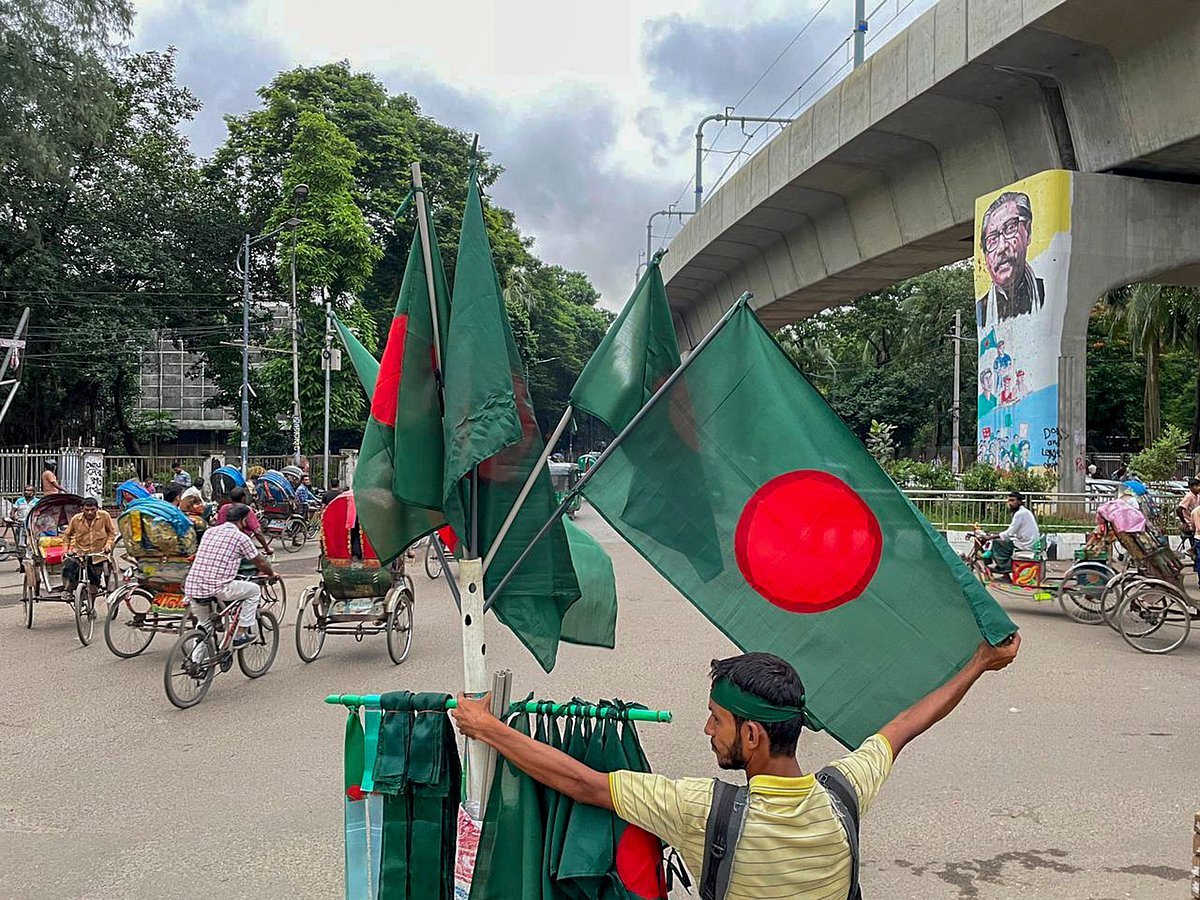 (PTI Photo) : Dhaka: A flag-seller stands on the periphery of a memorial site