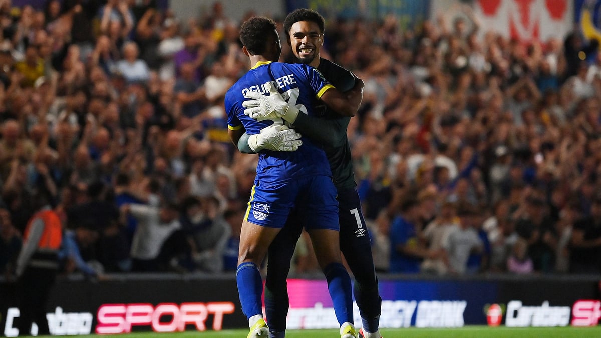 Owen Goodman celebrates with Isaac Ogundere after AFC Wimbledon defeat Ipswich Town on penalties
