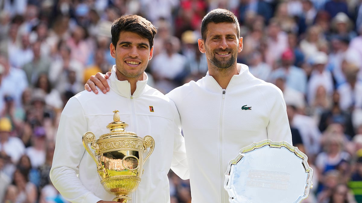 AP Photo/Kirsty Wigglesworth : Carlos Alcaraz, left, of Spain holds his trophy after defeating Novak Djokovic, right, of Serbia in the men's singles final at the Wimbledon tennis championships in London, Sunday, July 14, 2024.