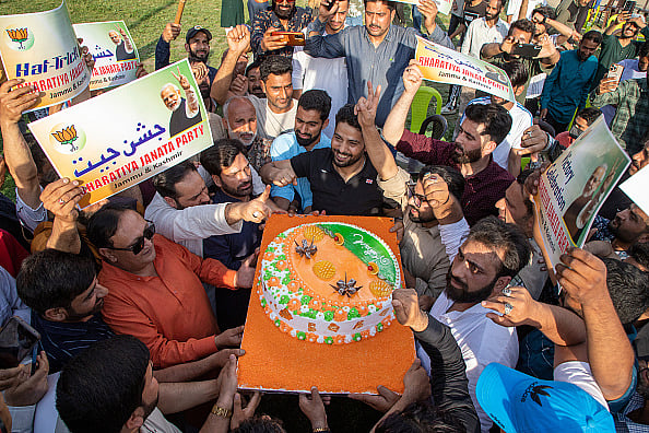  (Photo by Faisal Bashir/SOPA Images/LightRocket via Getty Images) : Supporters of Narendra Modi, India's Prime Minister and leader of the Bharatiya Janata Party (BJP), seen holding a cake as they celebrate vote-counting results for India's general election. India's Hindu nationalist Prime Minister Narendra Modi and his allies are expected to win the country's general election for a third term after a decade in power.