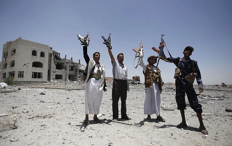 Houthis fighters hold weapons while chanting slogans |
