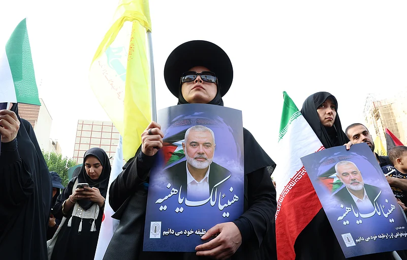 Iranians hold pictures of late Hamas Leader Ismail Haniyeh during a protest