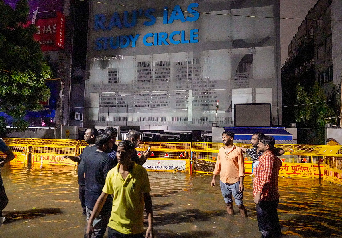 PTI : Students stand amid waterlogging in front of Rau's IAS Study Circle at Old Rajinder Nagar, in New Delhi, Wednesday, July 31, 2024