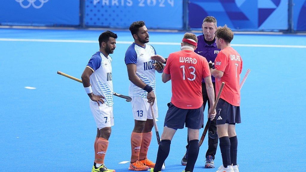 AP : India captain Harmanpreet Singh (second left) watches as the umpire Sean Rapaport speaks to Britain's Sam Ward (13) during the men's quarter-final hockey match at the Paris Olympics on Sunday (August 4).