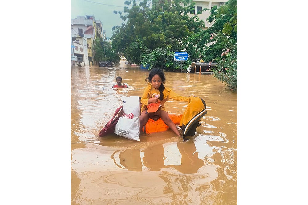 NDRF men evacuate people from a flood -hit area in Vijayawada