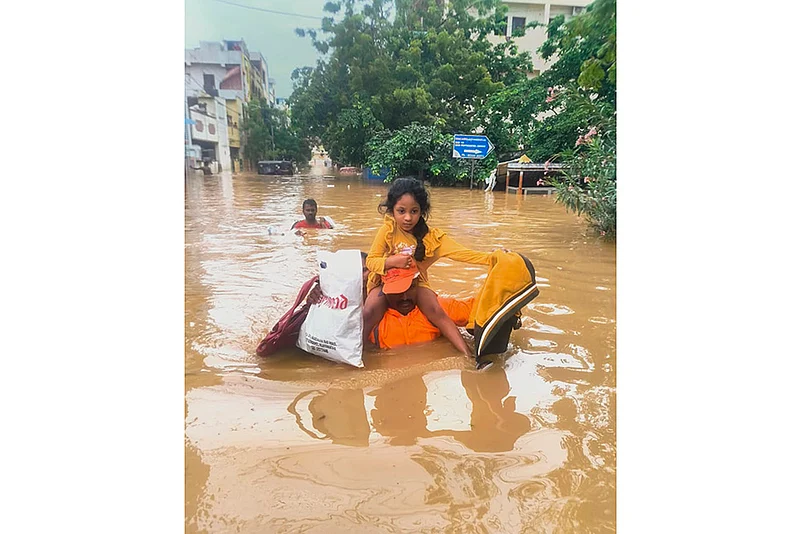 NDRF men evacuate people from a flood -hit area in Vijayawada