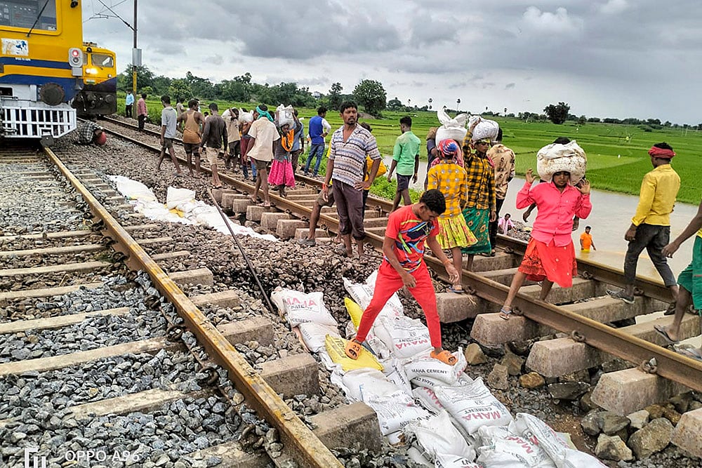 Workers restore a portion gravel under the railway track at Kesamudram, in Mahabubabad 