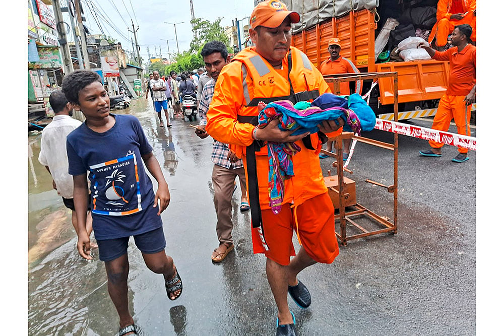 Vijayawada: NDRF men evacuate an infant from a flood -hit area