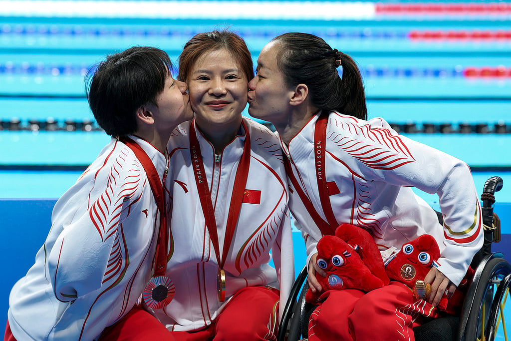 Lu Dong, He Shenggao and Liu Yu, of China, celebrate their first, second and third position at the podium of Women's 50m Backstroke -S5 during the 2024 Paralympics, Tuesday, Sept. 3, 2024, in Paris, France. - AP