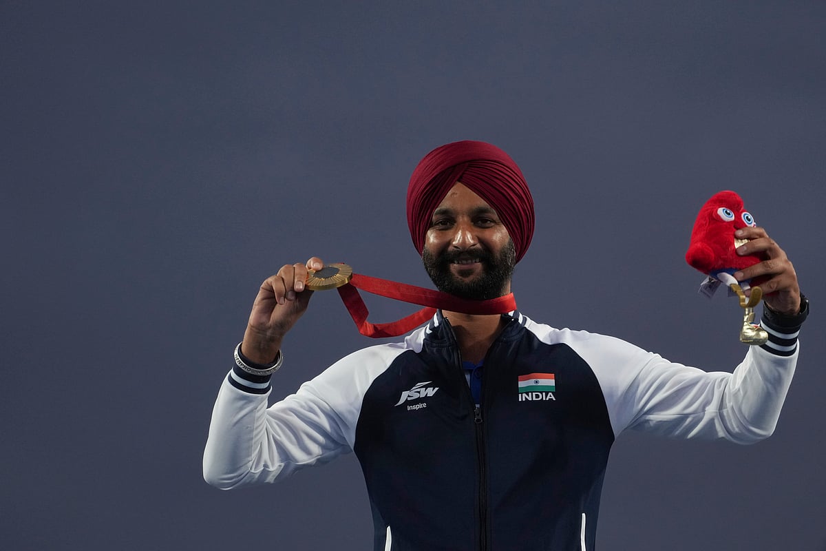 (AP Photo/Thibault Camus) : Harvinder Singh of India celebrates on the podium after winning the gold medal in the men's Individual Recurve Open, during the 2024 Paralympics, Wednesday, Sept. 4, 2024, in Paris, France.
