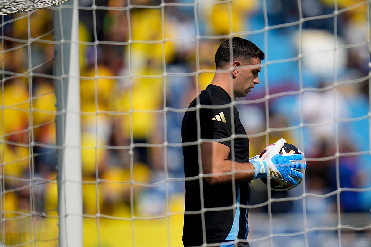 (AP Photo/Fernando Vergara) : Argentina's goalkeeper Emiliano Martinez holds a ball while warming up prior to a qualifying soccer match against Colombia for the FIFA World Cup 2026 at the Metropolitano Roberto Melendez stadium in Barranquilla, Colombia, Tuesday, Sept. 10, 2024. 