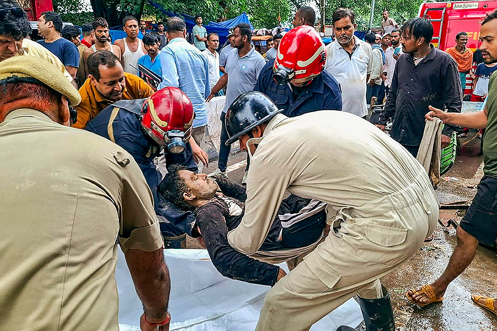 A person being rescued after a wall of a dargah collapsed at Nabi Karim area, in New Delhi