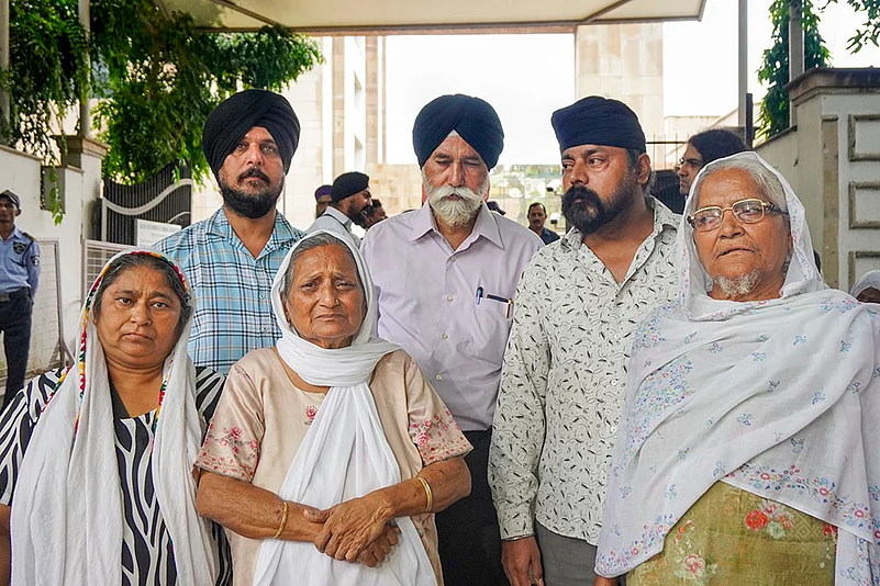 Family members of victims of the 1984 anti-Sikh riots speak with the media at Pul Bangash Gurudwara