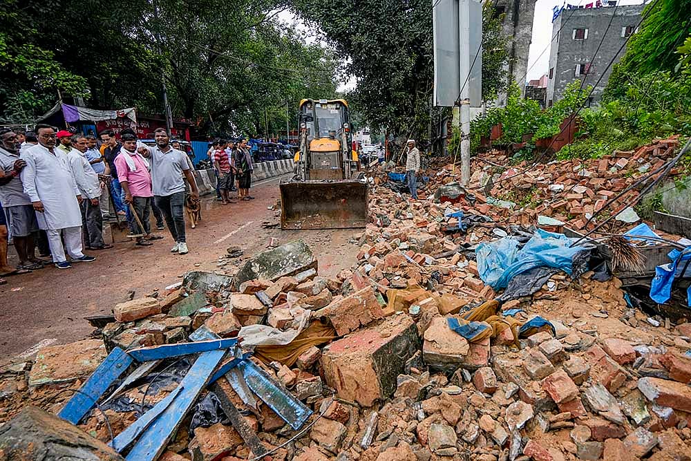 excavator is being used to remove the debris after Dargah wall collapses in Delhis Nabi Karim area