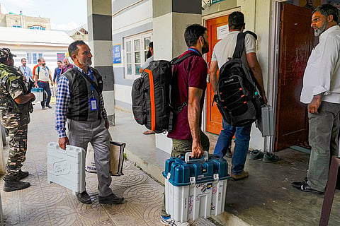 J&K Polls 2024, South Kashmir: Election Staff carrying EVMs arrive at a polling station 