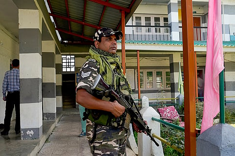 J&K Polls 2024, South Kashmir: A security personnel stands guard at a polling station