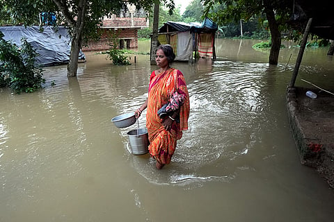 Bengal floods: A village woman walks through a flooded area in Howrah
