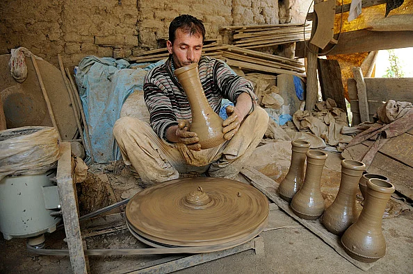 A potter works on an earthen Tumbaknari, a goblet drum traditional to Jammu and Kashmir