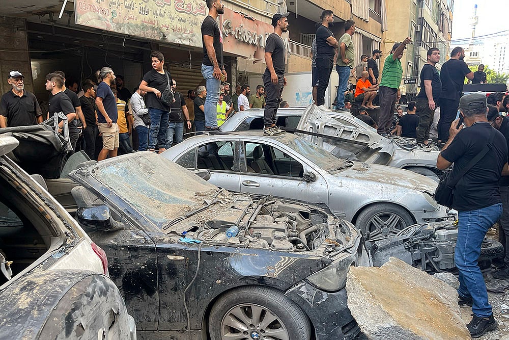 | Photo: AP/Bilal Hussein : Lebanon Mideast Tensions: People gather at the scene of an Israeli missile strike