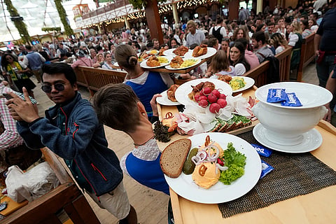Oktoberfest Opening: Waitresses carry traditional food plates at the Hofbraeuhaus beer tent 