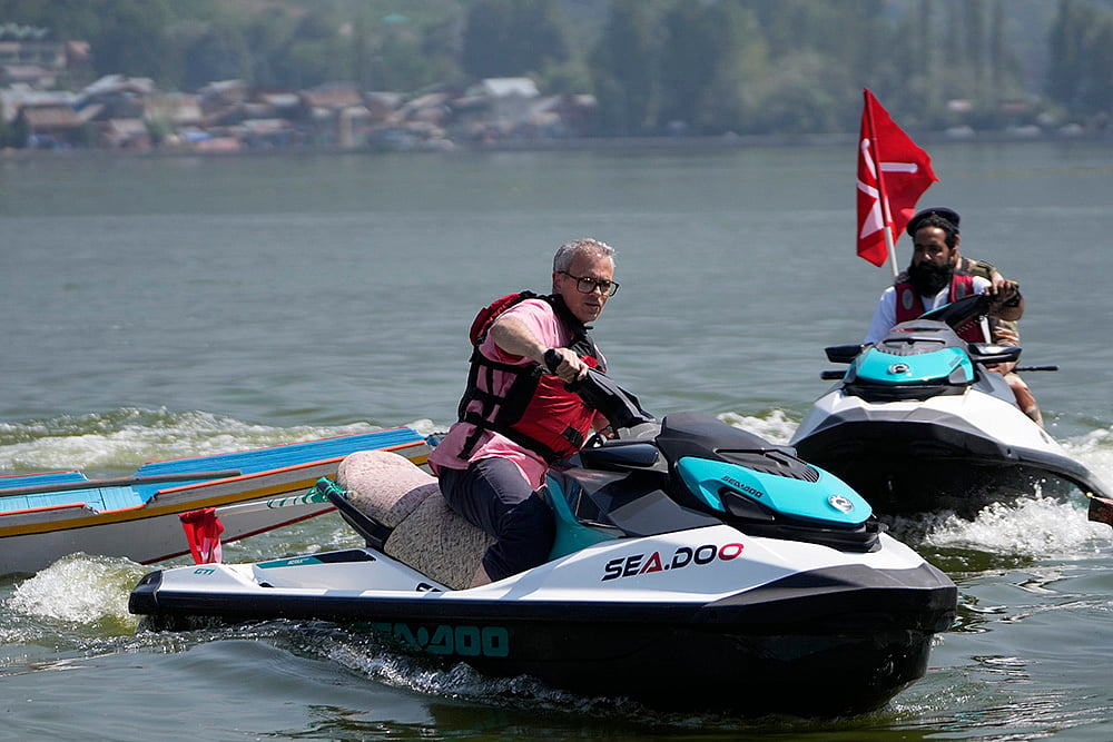 | Photo: AP/Mukhtar Khan : JKNC leader Omar Abdullah, rides a jet ski during an election rally at Dal Lake