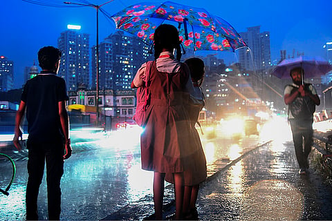 Rains in Mumbai: Students share an umbrella to shield themselves