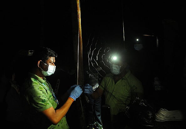 Photo by C. K Thanseer/DeFodi images via Getty Images : Team from the Pune National Institute and the Forest Department set up traps to find the source of the Nipah virus in Kodiyathoor