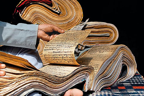 A sadhu looking at manuscripts